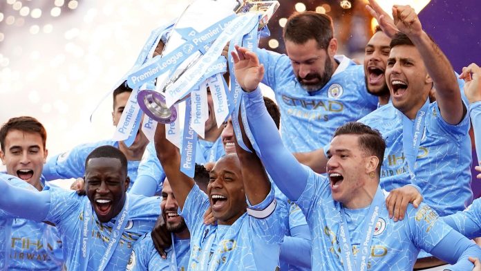 Manchester City's Fernandinho raises the trophy to celebrate winning the English Premier League title after the soccer match between Manchester City and Everton at the Etihad stadium in Manchester, Sunday, May 23, 2021.(AP Photo/Dave Thompson, Pool)