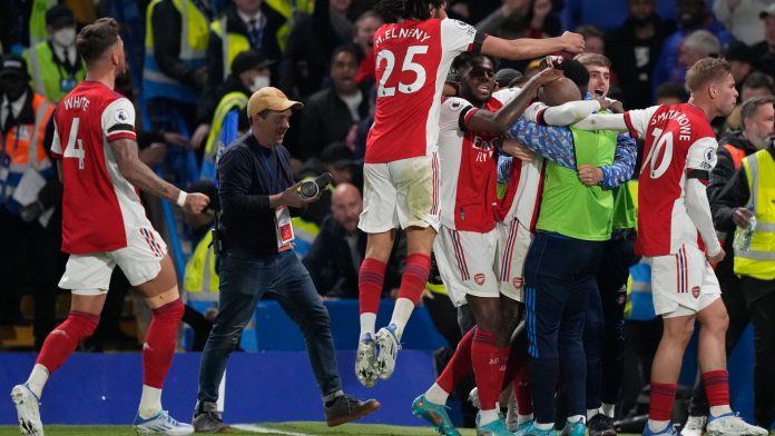Eddie Nketiah is mobbed by his team-mates as he celebrates scoring Arsenal's third goal (AP)