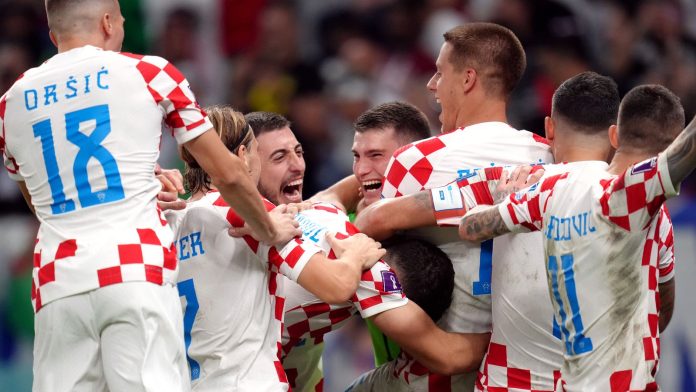 Croatia's goalkeeper Dominik Livakovic and team-mates celebrate after defeating Japan on penalties